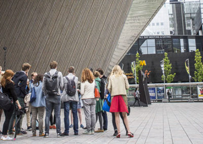 Tourgroep gaat van start met een rondleiding op Rotterdam Centraal.