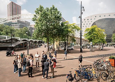 Busy urban square with people and bicycles.
